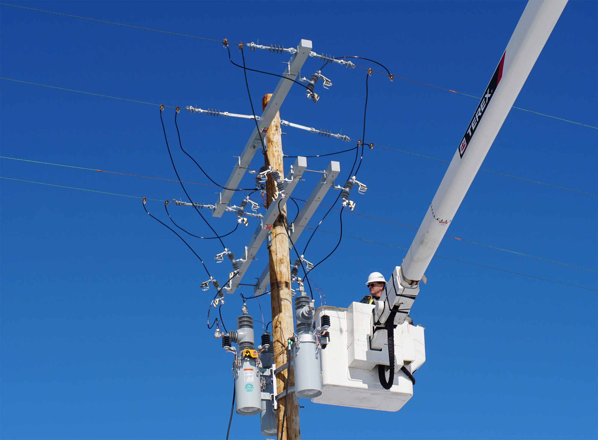 MEC Lineman sets up distribution automation capabilities on one of utility poles