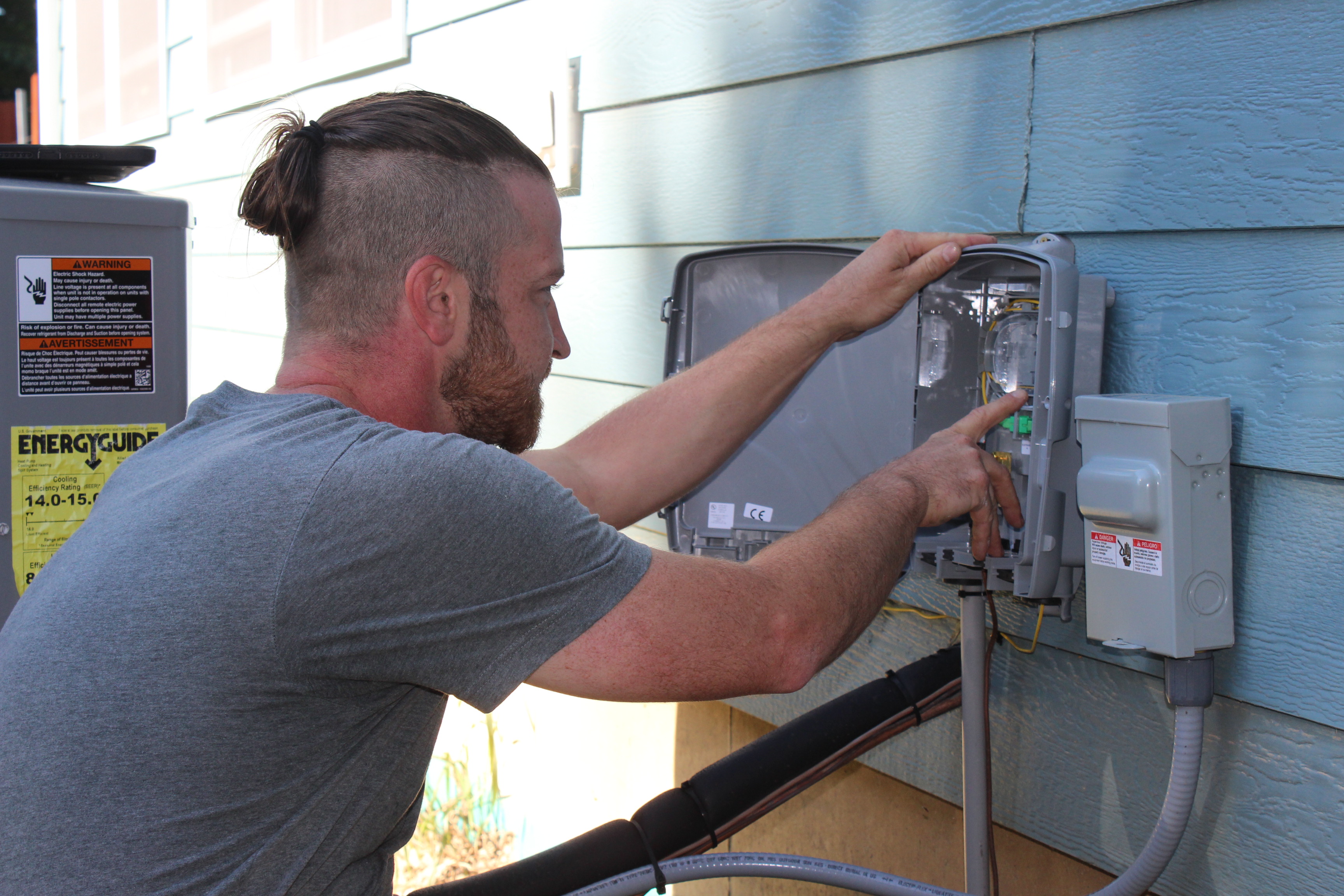 Fiber technician installing hardware to side of house