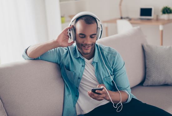 Man on sofa listening to music
